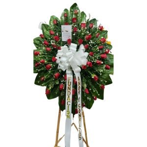Corona fúnebre con rosas rojas y follaje blanco