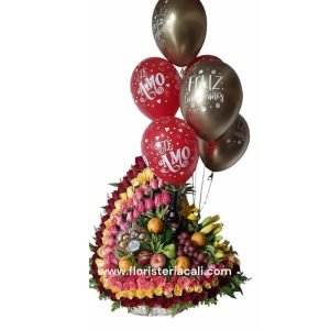 Arreglo floral en media luna con 100 rosas surtidas, frutas, lirios, follaje, chocolates Ferrero, botella mediana de crema de whisky y 6 globos metalizados.