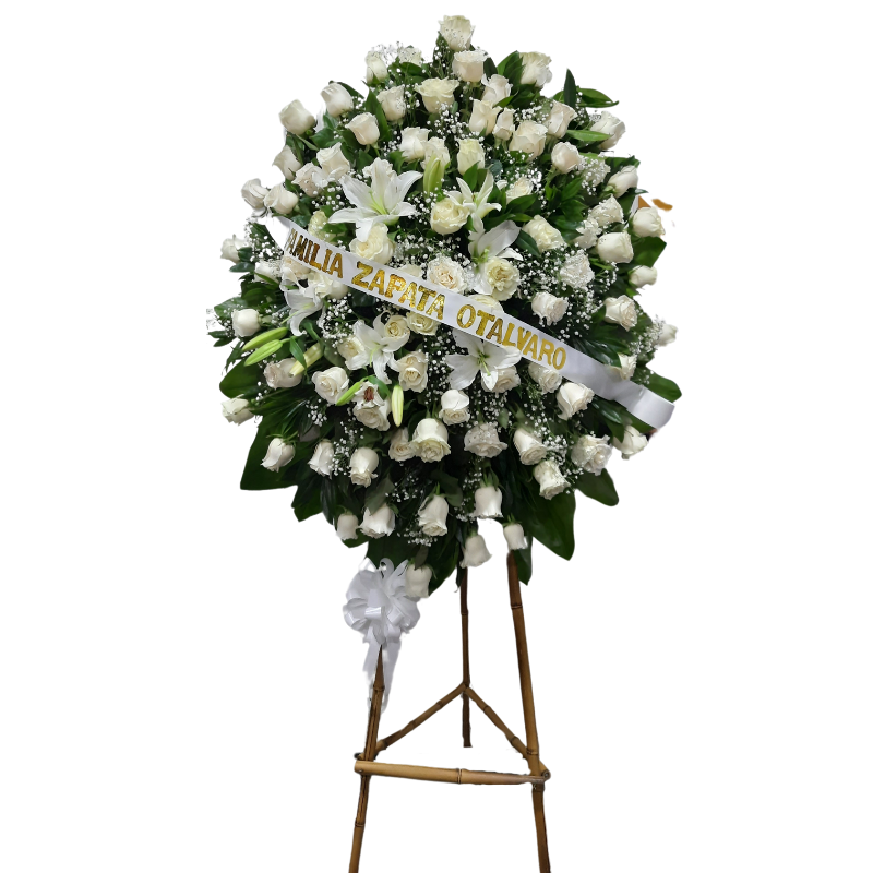 Corona fúnebre con rosas blancas, lirios y follaje blanco.